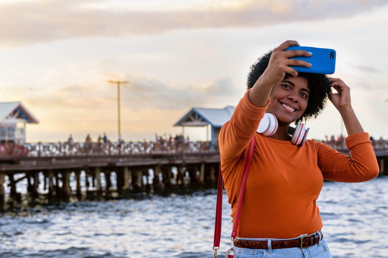 A closeup shot of a young attractive lady wearing headphones taking a selfie